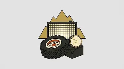 An off-road tire, a round headlight, and a vehicle grille set against a backdrop of tan mountains.