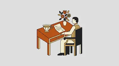 A person sits at a desk looking at a piece of paper next to a teacup and a vase of flowers.