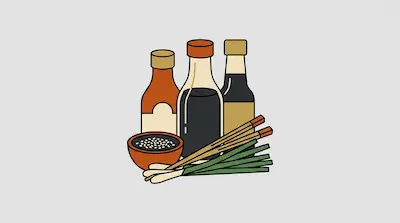 Three condiment bottles, a bowl of sesame seeds, chopsticks, and green onions.