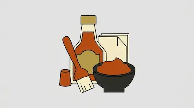 A sauce bottle, a bowl of dip, a basting brush, and a stack of napkins.