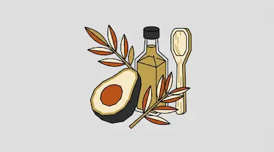 A halved avocado, a bottle of oil, a wooden spoon, and leafy branches.