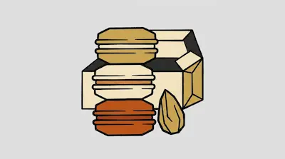 Three stacked macarons in shades of tan and orange next to an almond and a box.