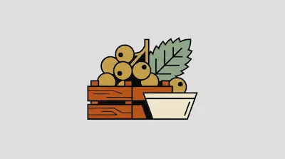 A wooden crate filled with tan berries and a green leaf sits next to a white bowl.