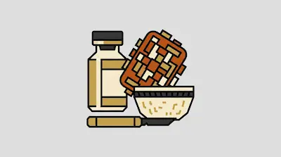 A bottle, a textured rectangular block, a bowl, and a knife.