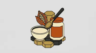 A bowl, a jar with an orange lid, a spoon, and an open seed pod clustered together on a tiled base.